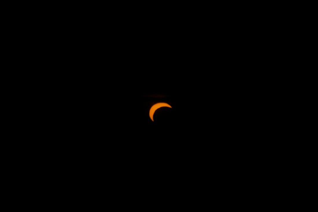The partially eclipsed Sun as an orange crescent over Slovakia
